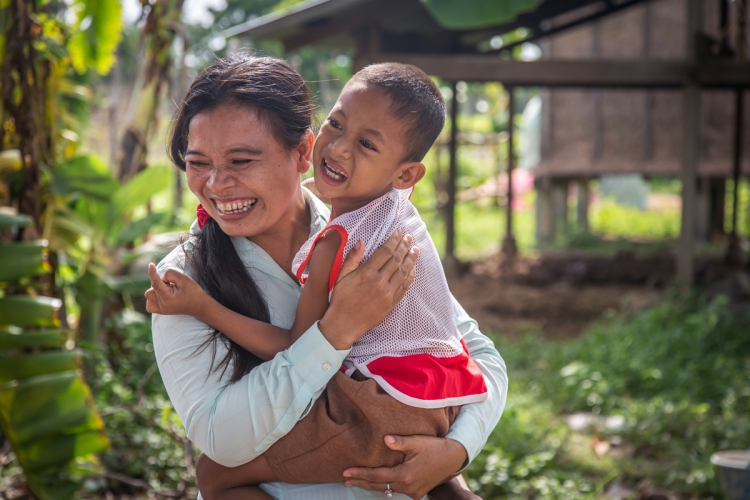 Disability worker Phearom with six-year old Vai Vin. (Photo: Anna Betts/OIC: The Cambodia Project)